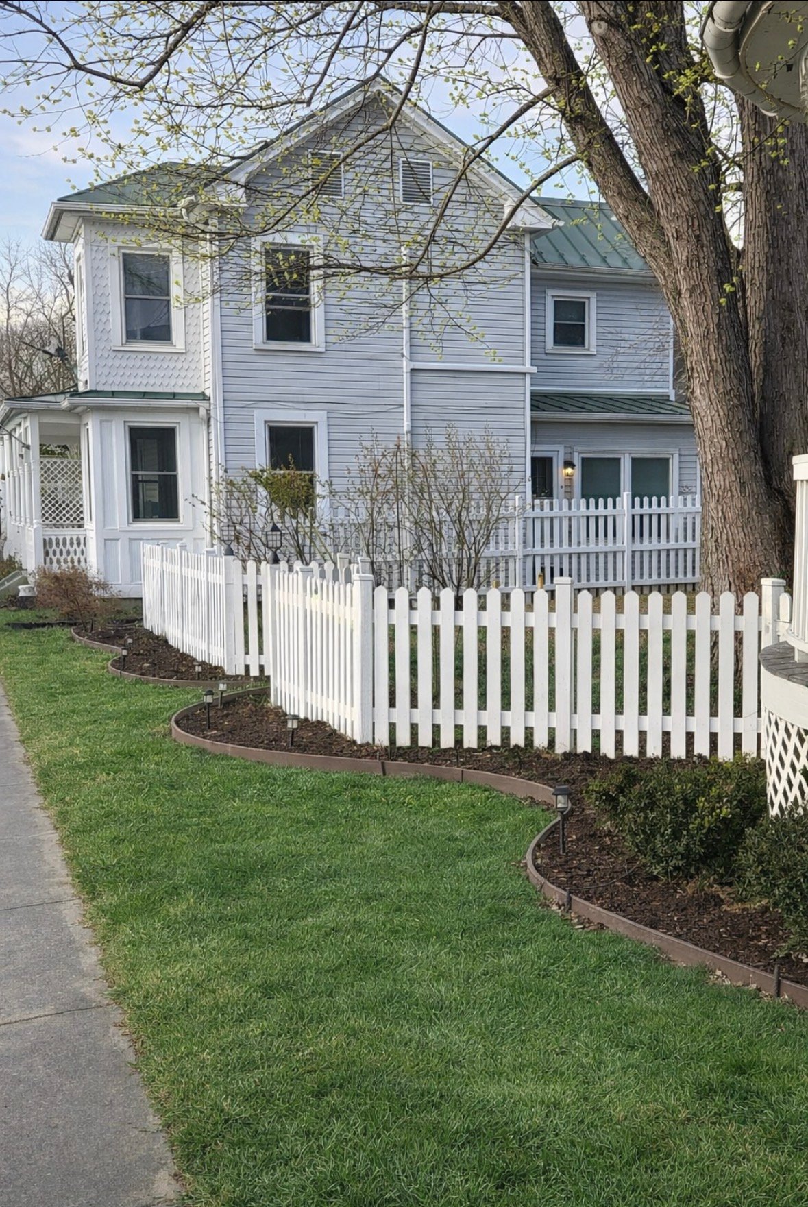 White vinyl picket fence along home frontage